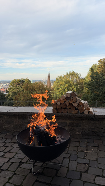Feuerschale mit brennendem Holz vor Bielefelder Stadtpanorama