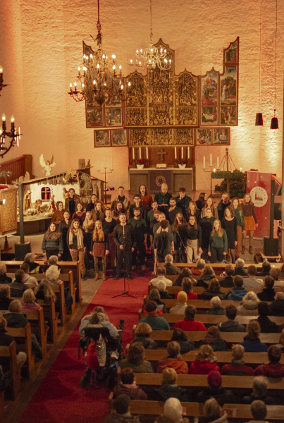 Die Sängerinnen und Sänger des KuMu Chores singen im Altarraum der Altstädter Nicolaikirche