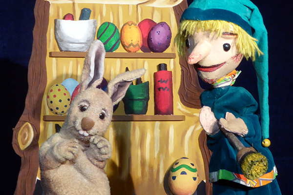 Kasper und Osterhase sitzen vor der Ostereierwerkstatt