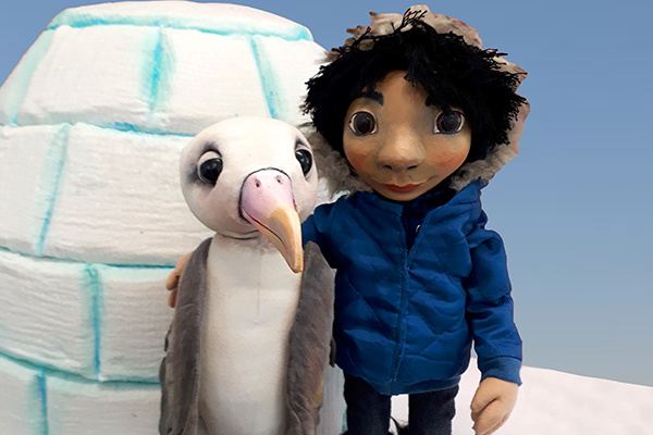 Pinguin und Inuitjunge Nuka vor Iglu