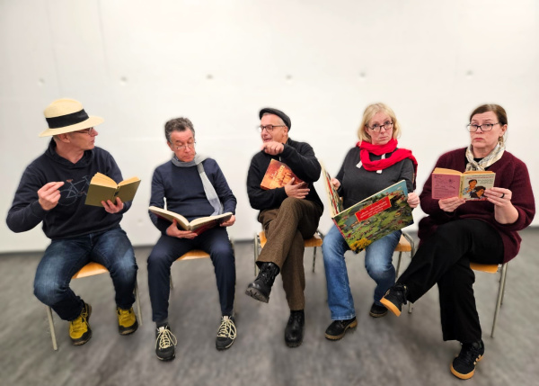 Fünf Personen sitzen und lesen