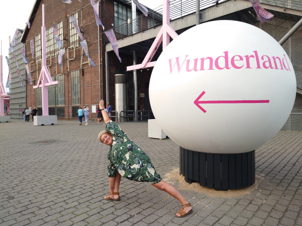 Yogahaltung vor einer Kugel mit der Aufschrift Wunderland