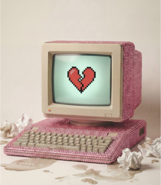 Ein rosa, mit glitzernden Steinen verzierter Retro-Computer zeigt auf dem Bildschirm ein pixeliges, 