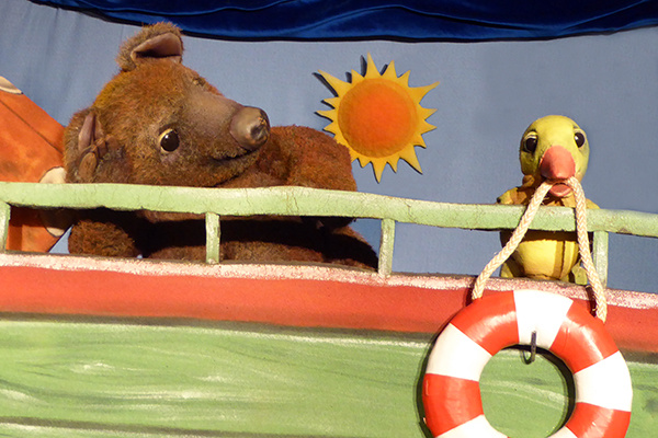 Bär mit Vogel auf einem Boot