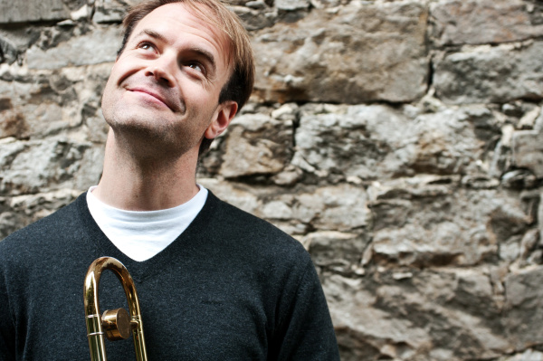 Shawn Grocott mit Posaune vor einer Wand
