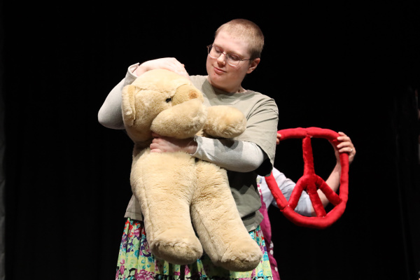 eine Person streichelt behutsam einen großen Teddybären